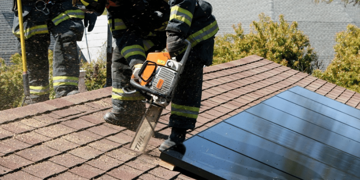 Firefighter entering a house with solar panels in an emergency situation 