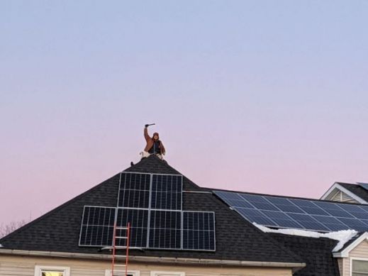 Man working on solar installation on roof